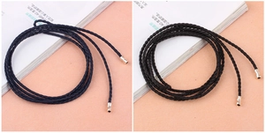Detail of woven knotted dress belt with metal end caps in navy blue and black
