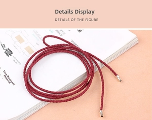 Close-up of a dark red braided waist belt with shiny gold alloy cylindrical end caps
