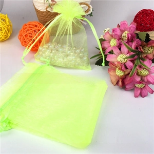 Detailed view of neon green organza drawstring gift bags with pearl decorations