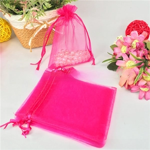 Macro detail of rose pink organza drawstring bags showing sheer mesh fabric and silk ribbons