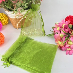 Detailed view of light green organza drawstring gift bag with white faux pearls
