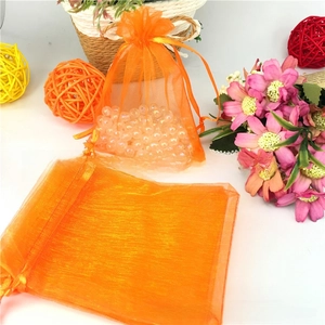 Detail of orange organza drawstring pouch with translucent mesh fabric and silk ribbons