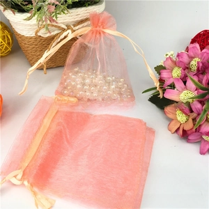 Detailed view of pink organza drawstring gift bags with pearlescent bead filler