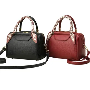 Detail of Boston style leather bags with decorative silk scarves on handles and fine texture