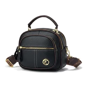 Mini borsa rotonda in pelle nera con logo oro e telefono come riferimento