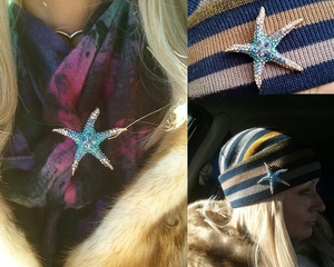 Detailed view of starfish brooch with crystals styled on a scarf and knit hat