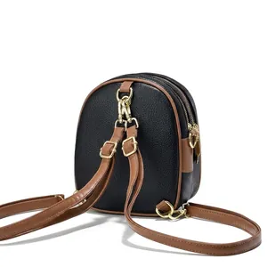 Detailweergave van de zwarte lychee lederen minitas met goudkleurige hardware