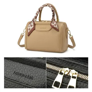 Detail of lychee pattern leather bag with Fashion & Bag logo and decorative silk scarf