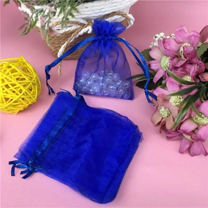 Detail of royal blue organza drawstring gift bag with semi-transparent mesh texture