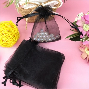Close-up of black organza drawstring pouch with satin ribbon for jewelry packaging