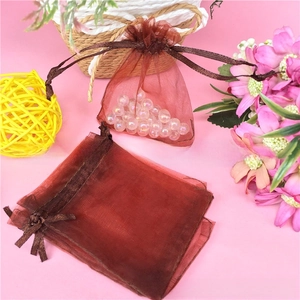 Close-up of wine red organza drawstring pouches used for jewelry and gift packaging