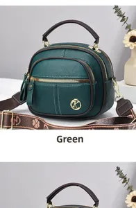 Dettaglio della borsa a tracolla verde scuro con trama litchi e logo dorato