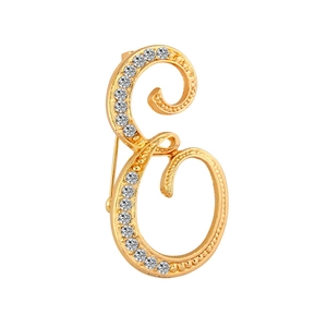 Detailed close-up of a gold-plated letter E brooch encrusted with sparkling rhinestones