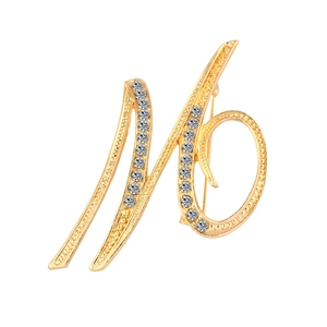 Detailed close-up of a gold-plated letter N brooch with sparkling crystal rhinestones