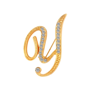 Close-up of golden letter Y brooch featuring sparkling crystals and polished finish