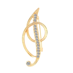 Macro detail of high-end golden treble clef brooch with sparkling crystal rhinestones