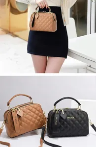 Detail der gesteppten Handtasche mit MQCKDE-Logo und zwei Reißverschlussfächern