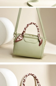 Detail of light green pebbled leather handbag with houndscall scarf wrapped on handle