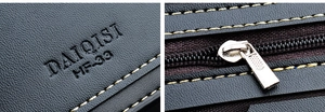 Détail du portefeuille en cuir noir grainé avec logo DAIQISI et couture jaune