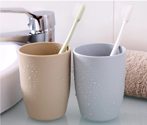 Close-up of beige and light blue tooth mugs with realistic water drops in bathroom setting