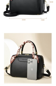 Detail of black lychee leather handbag with golden hardware and decorative silk scarf