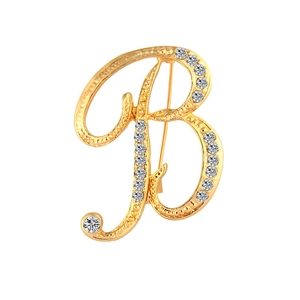 Elegant gold-tone letter B brooch with sparkling round rhinestones on white background