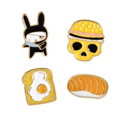Detailed view of four cartoon enamel pins featuring a bunny, burger, toast, and sushi
