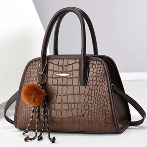 Detaillierte Nahaufnahme der dunkelbraunen Handtasche mit Kroko-Muster und Goldakzenten