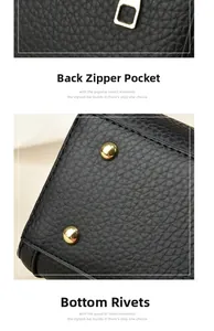 Close-up of black lychee grain leather bag with gold zipper and protective bottom studs