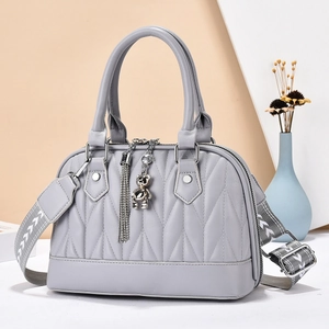 Chic mauve pleated handbag with geometric shoulder strap and silver bear charm