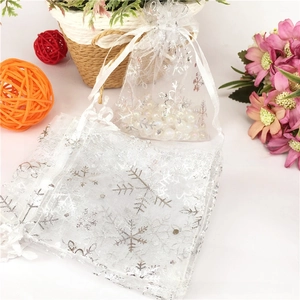 Detail of white organza gift bags with silver snowflake print and silk drawstring