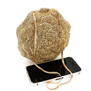Detail of rose-shaped evening bag with gold rhinestones and elegant chain strap