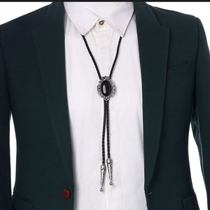 Detail of vintage silver crown bolo tie with black cat eye stone and braided leather cord