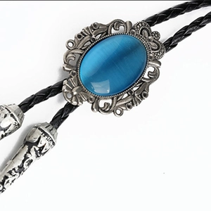 Detail of blue cat eye stone bolo tie with vintage silver floral metal carving