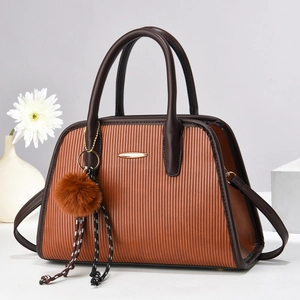 Brown textured women's tote bag with dark trim and decorative plush charm ornament