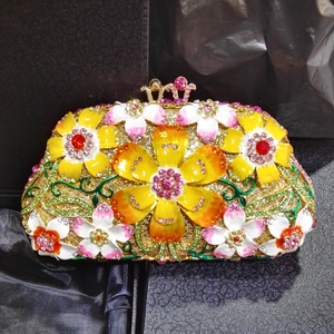 Detailed close-up of crystal evening clutch with enamel flowers and gold rhinestone finish