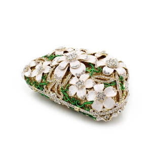 Detailed macro of white enamel flowers and clear rhinestones on golden evening clutch