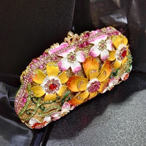Detail of crystal rhinestones and enamel flowers on the golden evening clutch bag