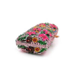 Macro detail of floral evening clutch with pink and yellow crystals and enamel finish
