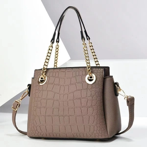 Elegant taupe croc-embossed crossbody bag with golden chain handles and long strap