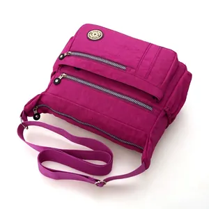 Borsa a tracolla in nylon fucsia con tasche multiple a zip e cinturino regolabile