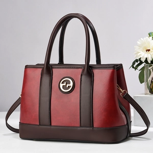 Elegante borsa a mano bicolore bordeaux e marrone con dettaglio logo circolare dorato