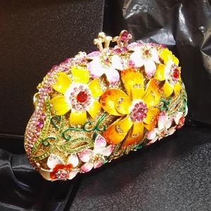 Detailed macro of crystal-encrusted evening bag featuring colorful enamel flower motifs
