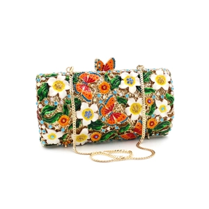 Detailed close-up of luxury gold evening clutch bag with enamel flowers and crystals