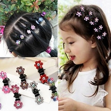 Dettaglio di fermagli per capelli a fiore con strass colorati e mini clip nera