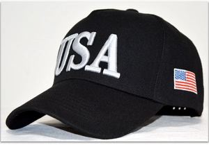 Detail of white USA 3D embroidery and American flag patch on a black cotton baseball cap