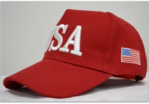 Detailed close-up of white USA embroidery and American flag on red cotton baseball cap
