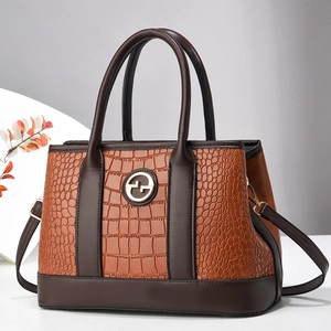 Elegante borsa a mano marrone con texture coccodrillo e logo dorato in un set minimalista