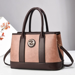 Pink pleated tote bag with brown leather trim and golden logo in a stylish setting