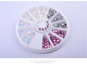 Detail view of colorful AB acrylic nail art rhinestones in a white circular rotating storage box